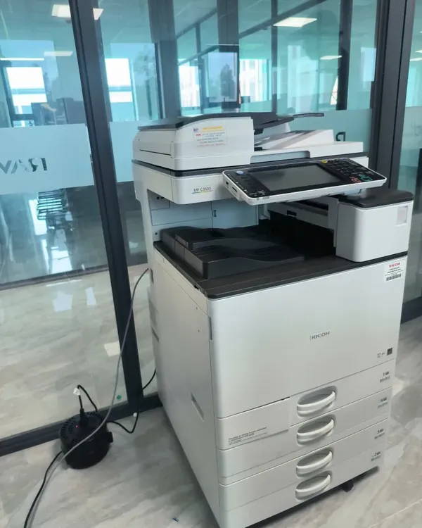 M&aacute;y photocopy m&agrave;u Ricoh MP C3503 của Nguy&ecirc;n Ph&aacute;t đặt trong văn ph&ograve;ng c&oacute; v&aacute;ch k&iacute;nh